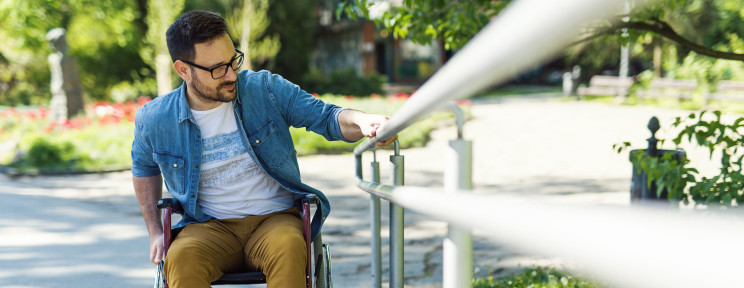 Paralyzed young man in a wheelchair climbing up